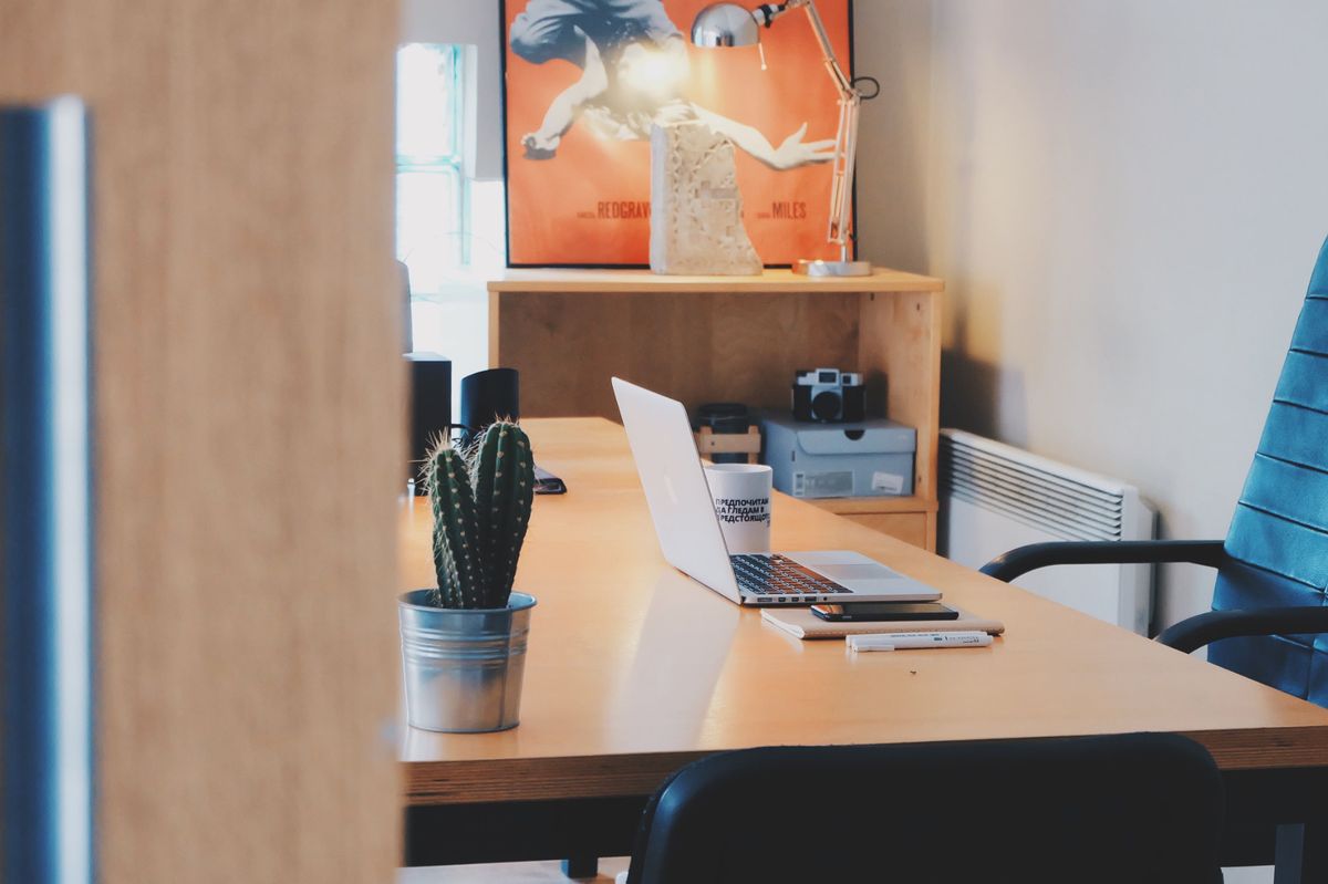 Quiet office desk with a laptop and notebook used for a focused job search
